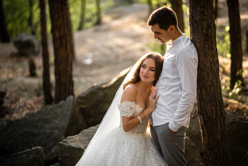 Newlyweds hugging in the forest in the sunlight of the day
