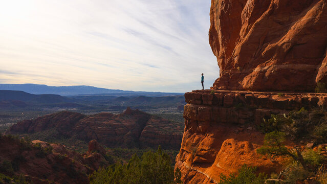 Hiker on cliff edge of Cathedral Rock in Sedona, Arizona USA