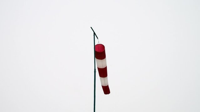 video of a wind sleeve to signal wind direction and intensity placed at a parachute airfield isolated on white sky