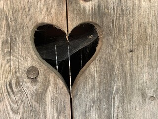 Herz in Holztüre ausgeschnitten - Herzen Symbol aus Holz mit Spinnennetz als Textur oder Motiv...