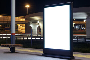 Billboard on the passenger platform of a railway station at night.Mock-up.