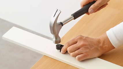 Closeup of person hammering a nail.