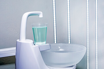 glass of liquid for rinsing teeth in a dental office. dental treatment and care