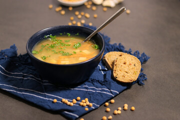 Close up of vegetarian yellow peas soup in bowl with slices of olive bread