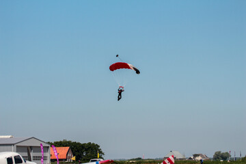 A skydiver with a red parachute in the air