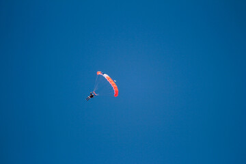 A skydiver with a red parachute in the air