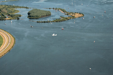 An airplane, a Cessna 172, flying over the water near Knarland Island with a harbor and sailboats