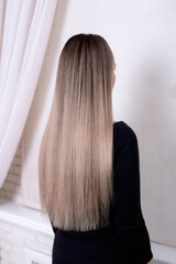 
Female back with long straight natural blonde hair in hairdressing salon
