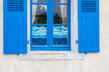 Fototapeta na wymiar Hausfassade mit blauem Fenster, Bretagne