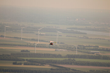 Aerial shot of an ultralight aircraft in flight over the landscape