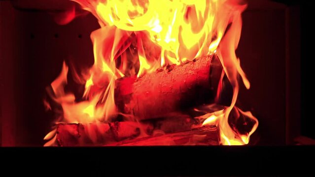 Close-up view of a fireplace in a house with burning wood and the crackling sound of the fire.