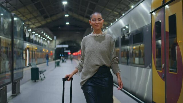 Trendy girl walking train station looking camera smiling. Short hair woman going