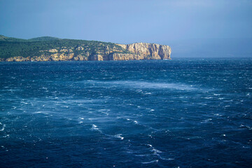 waves and rocks, Mistral storm in the gulf of Porto Conte, in the background the promontory of...
