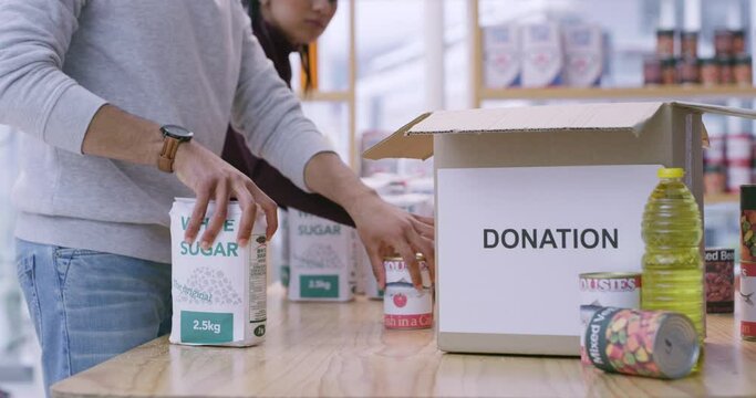 Hands, box and donation as volunteer or canned food for charity service, society or responsibility. People, teamwork and grocery parcel or package or help distribution nonprofit, kindness or outreach