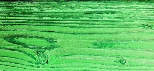 A board painted green from pine wood damaged under the influence of weather conditions
