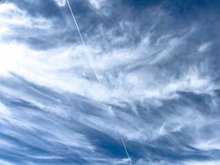 blue sky with thin clouds and contrail
 - Powered by Adobe