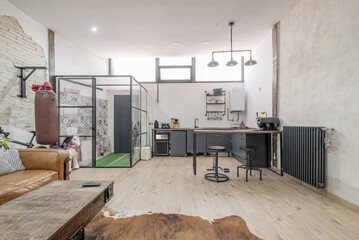 Large open-plan living room of a loft-type apartment with industrial-type decoration with metal...