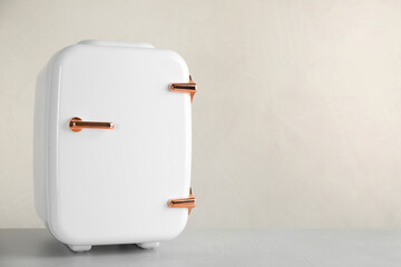 Cosmetic refrigerator on beige background, space for text