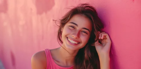 Deurstickers Junge hübsche Frau lächelt, Mädchen mit rosa Oberteil vor einer rosa Wand © GreenOptix