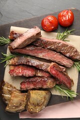 Delicious grilled beef with tomatoes and rosemary on table, top view