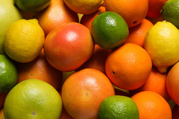 Different fresh citrus fruits as background, top view