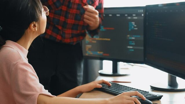 Slow motion back end or software developer manager supervising his team on new application program development on debugging and solving complex code algorithms on monitor. Burgeoning