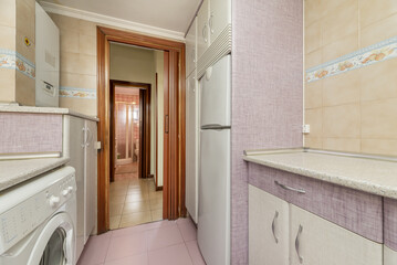 The kitchen is furnished with white wooden furniture combined with fuchsia, aluminum handles and integrated white appliances