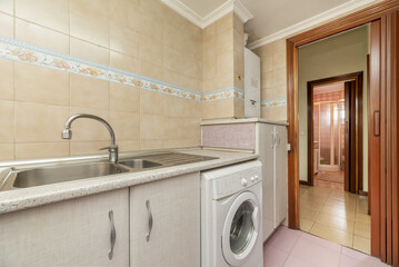 Kitchen is furnished with white wooden furniture combined with fuchsia, aluminum sink with chrome faucet, and integrated white appliances