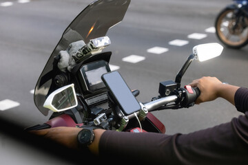 Close up photo of motorcycle or maxi scooter driver in helmet use smartphone application to find...