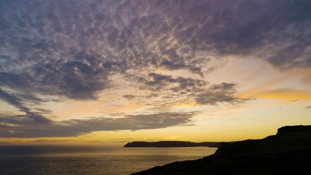 Sunset clouds time lapse over beautiful coastal view