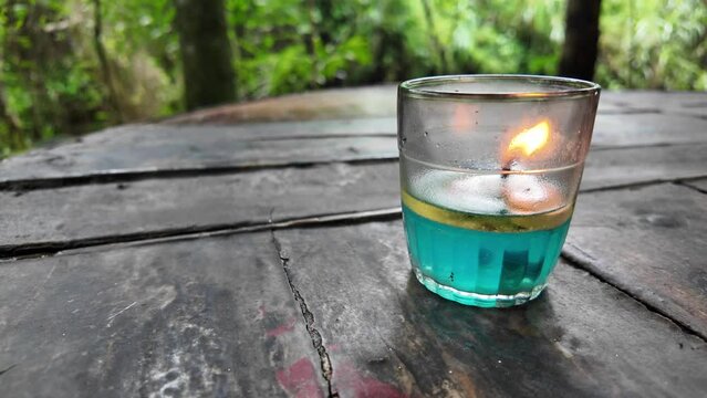 4k video footage of Oil lamps or kerosene lamp lantern with fire inside the glass on wooden table. Old traditional storm lamps. Liquid candle.