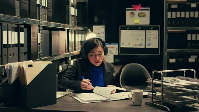 Agent extracting cryptic references found in classified records that may require further deciphering or analysis, archive room work. Law officer trying to break codes to find details. Camera B.