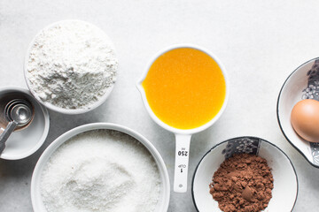 mise en place of ingredients for making brownies, top view of sugar, eggs, butter, flour cocoa...