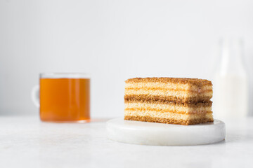 Fototapeta na wymiar slice of vanilla cake with jam filling, thin layers of vanilla and chocolate cake with jam filling on a white background