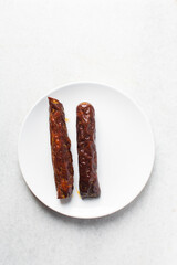 Top view of chinese sausage in a white plate, overhead view of lap cheong sausage on white background