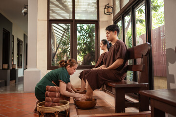 Relaxation Asian couple customer feel happy and satisfied with the service massage in spa salon. Masseur washing feet of woman customer. - obrazy, fototapety, plakaty