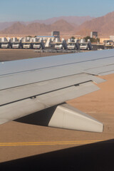 The plane lands on the airfield. Spoilers and flaps trailing edge when landing. View of the earth from the wing of the aircraft. Sinai. Sharm El Sheikh, Egypt.