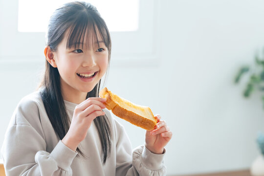 笑顔でトーストを食べる女の子