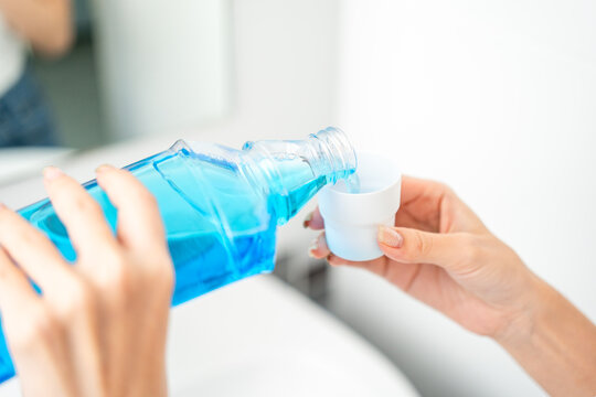 Young asian woman with mouthwash for the health of teeth in restroom. Take care and good dental health fresh breath with mouthwash.