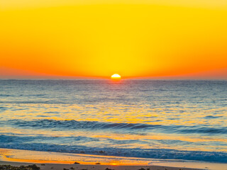 Sunrise seascape with clear skies and orange horizon