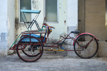 a rickshaw parked on the side of the road. - obrazy, fototapety, plakaty