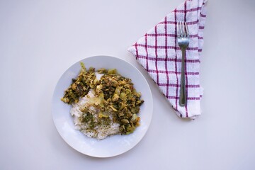 arroz, servilleta y verduras salteadas en un plato con fondo blanco