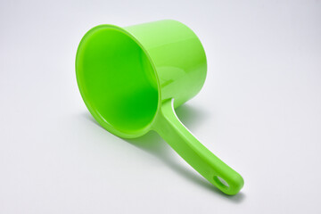 Green plastic ladle on a white background