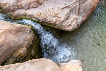 Low waterfall in the path of the shallow stream in the gorge Wadi Al Ghuwayr or An Nakhil and the wadi Al Dathneh near Amman in Jordan