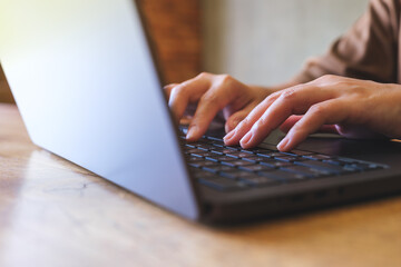 Closeup image of hands working and typing on laptop computer keyboard