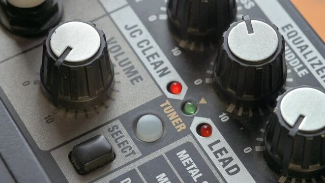 Man adjusting volume knob on guitar amplifier. 4k video footage UHD 3840x2160