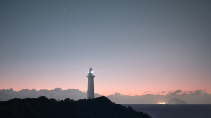 夜明けを迎える爪木崎灯台と星空