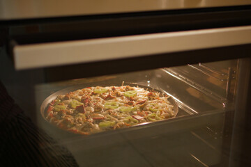 Homemade pizza is baked in a modern electric oven.