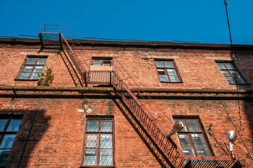 A fire escape ladder near the wall of a brick building.