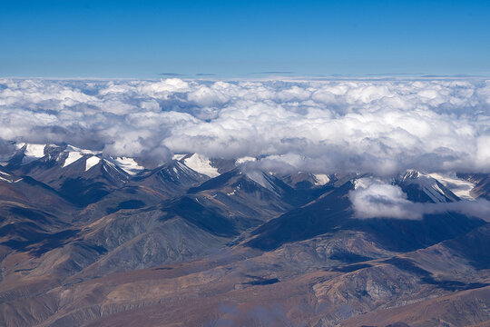 Eye Level view of rainbow colored mountain with patches of cloud shadow and snow on the hills